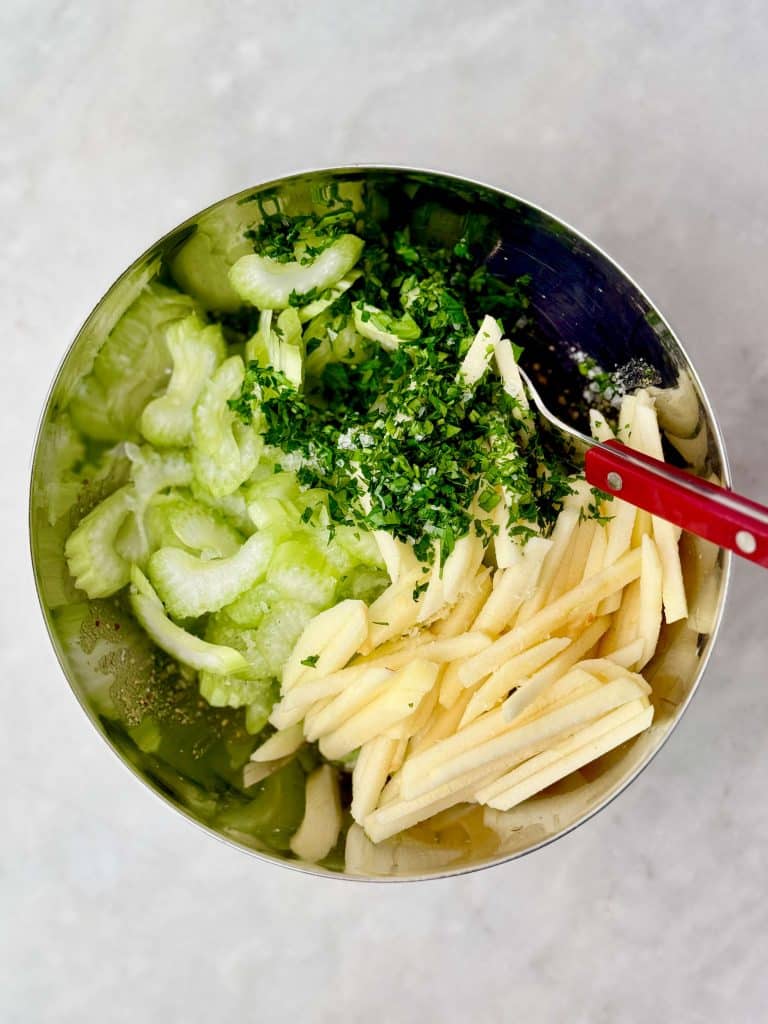 Thinly sliced celery, julienned apple, and fresh parsley for celery apple slaw.