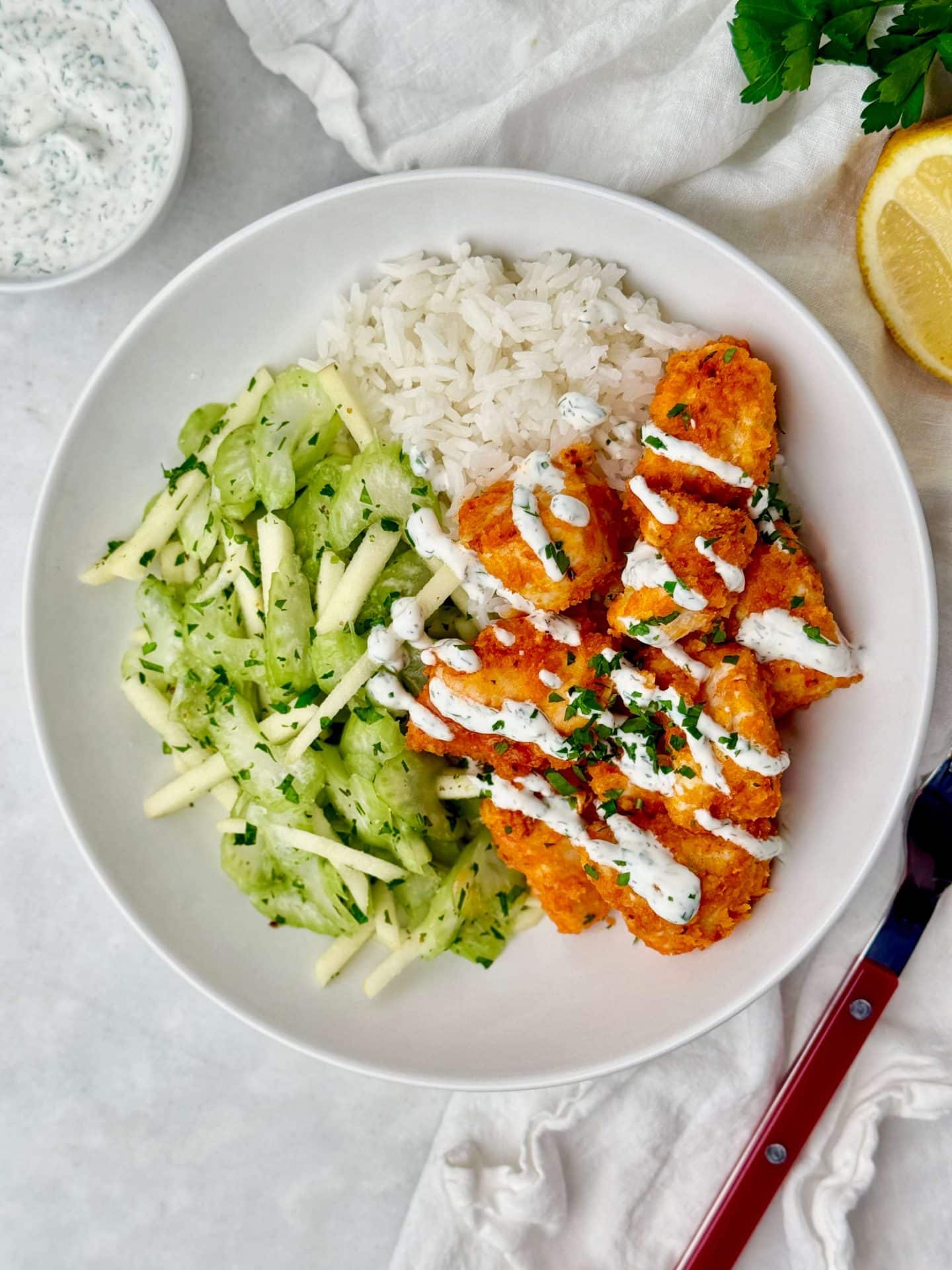 High protein buffalo chicken rice bowl with crunchy celery slaw and creamy Greek yogurt ranch.