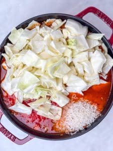 Chopped cabbage and rice added to tomato bone broth for unstuffed cabbage soup