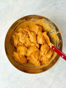 Yogurt-marinated chicken tikka with spices ready to be cooked in the air fryer