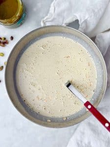 Creamy blended pistachio overnight oats mixture made with milk, Greek yogurt, protein powder, and pistachios
