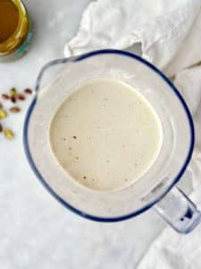 Smooth high-protein pistachio overnight oats base blended with yogurt, milk, protein powder, and pistachios