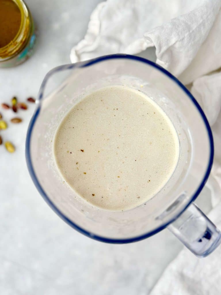 Smooth high-protein pistachio overnight oats base blended with yogurt, milk, protein powder, and pistachios