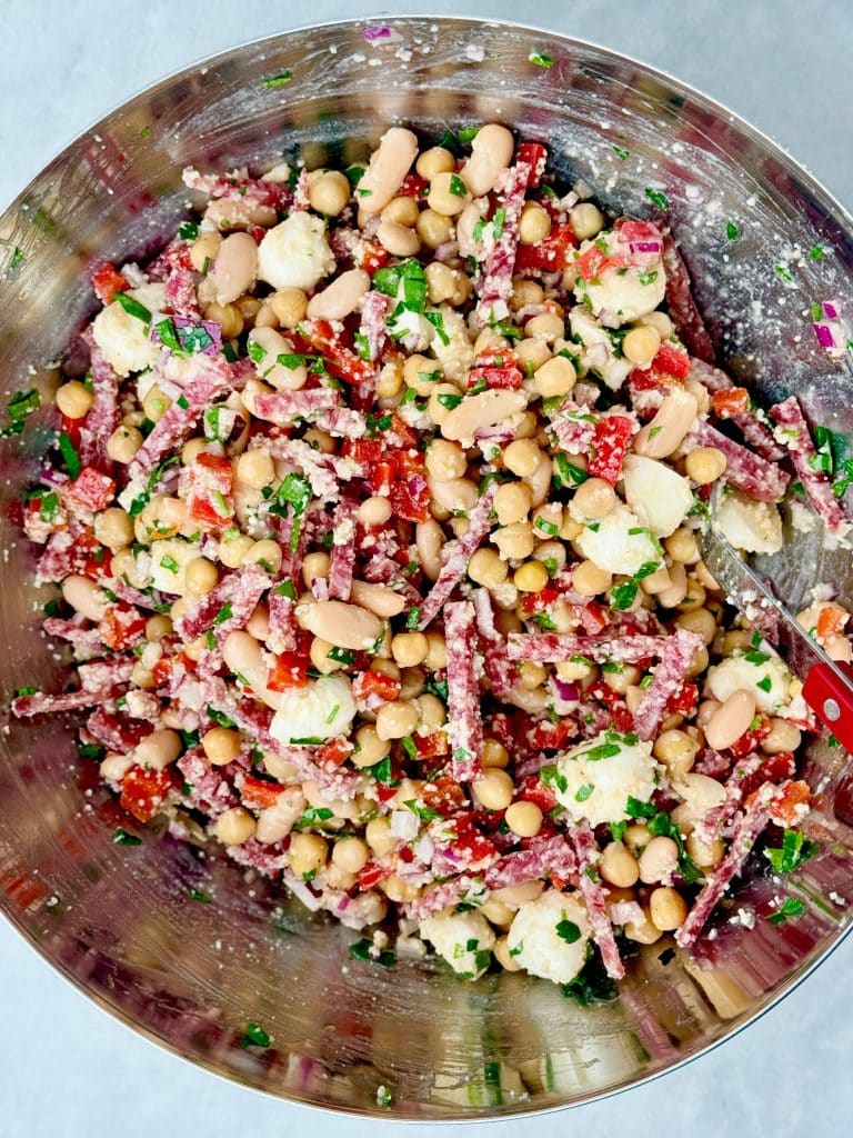 La Scala dense bean salad tossed together with chickpeas, cannellini beans, salami strips, mozzarella pearls, roasted red peppers, and fresh parsley.