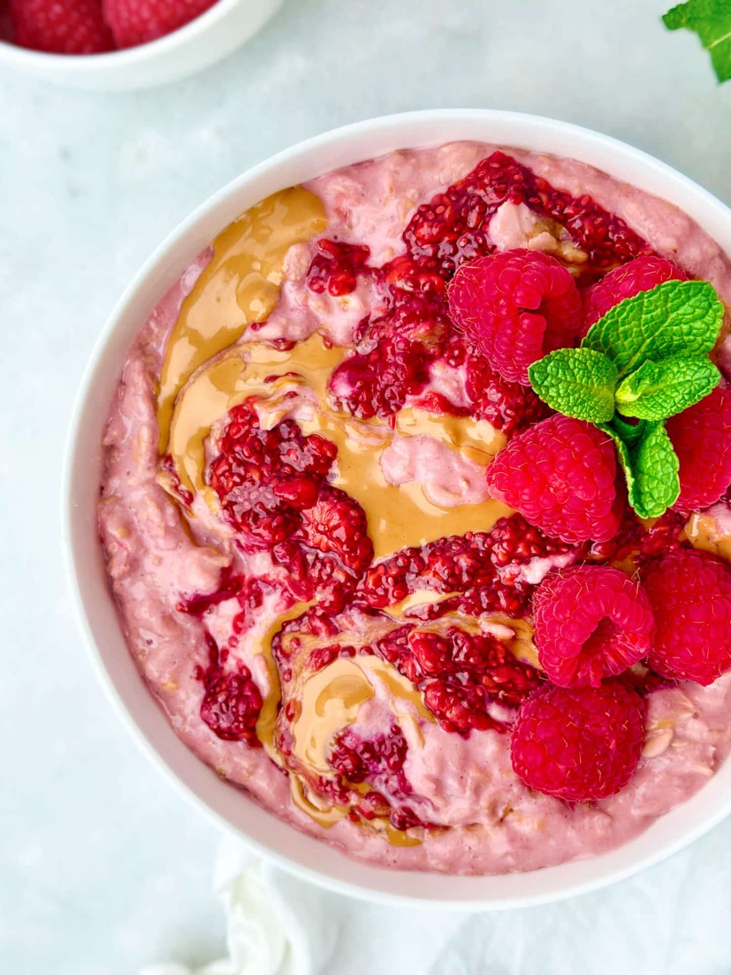 high protein pb&j oatmeal bowl topped with raspberries.