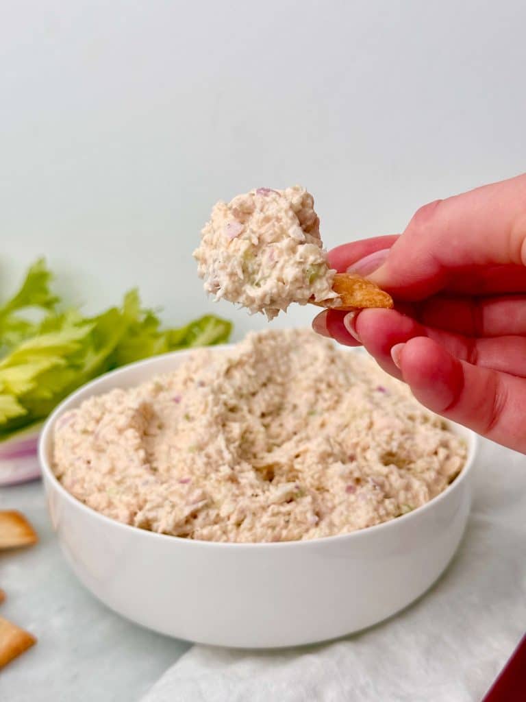 Close-up of Round Swamp chicken salad copycat scooped onto a cracker, showing the smooth, finely shredded texture.