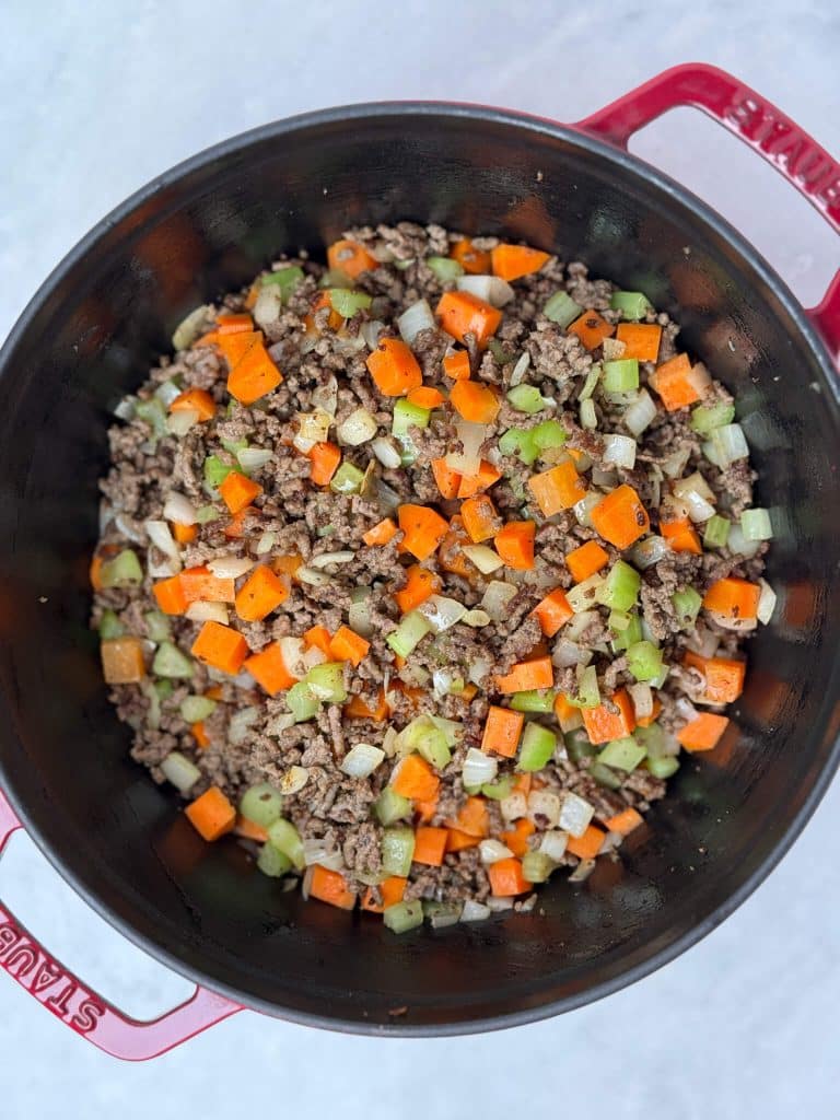 Ground beef cooked with carrots, celery, and onion for flavorful unstuffed cabbage soup