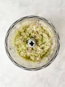 Finely pulsed celery and shallot in a food processor for Round Swamp Farm chicken salad copycat recipe.