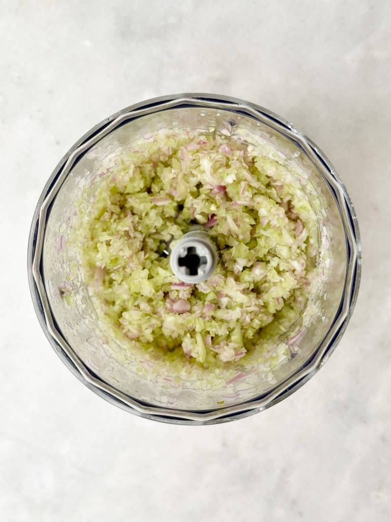 Finely pulsed celery and shallot in a food processor for Round Swamp Farm chicken salad copycat recipe.