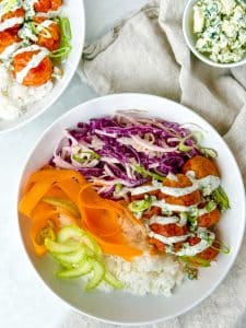 Two air fryer buffalo chicken meatball bowl with rice, cabbage slaw, and ranch drizzle.