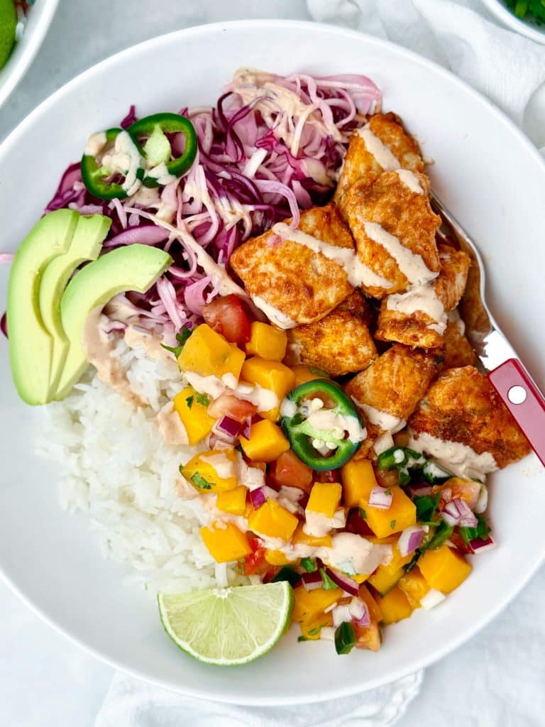 Close-up of air fryer fish taco bowl showing crispy fish pieces with chipotle crema drizzle