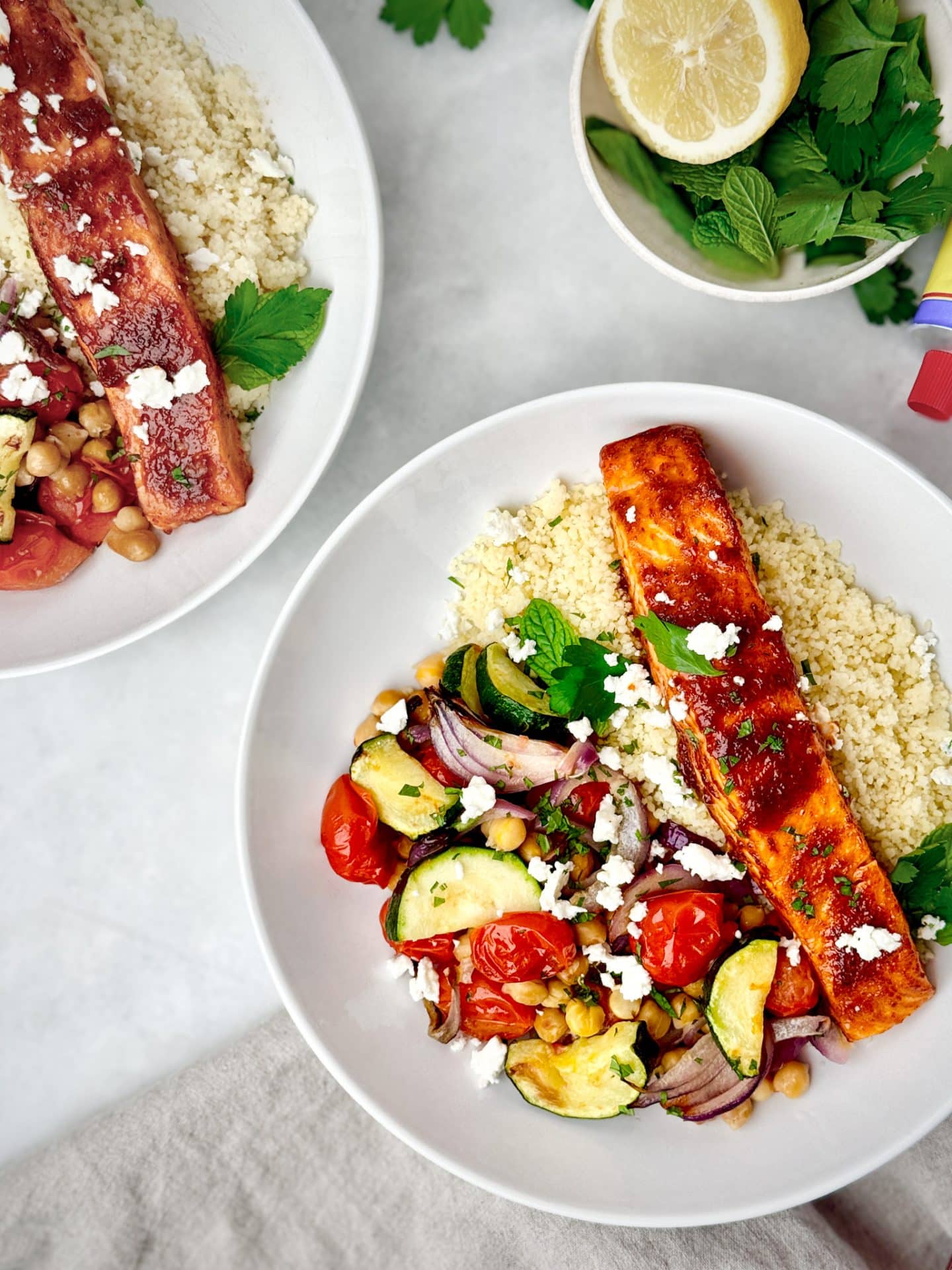 Air fryer honey harissa salmon bowl over couscous with feta and fresh herbs
