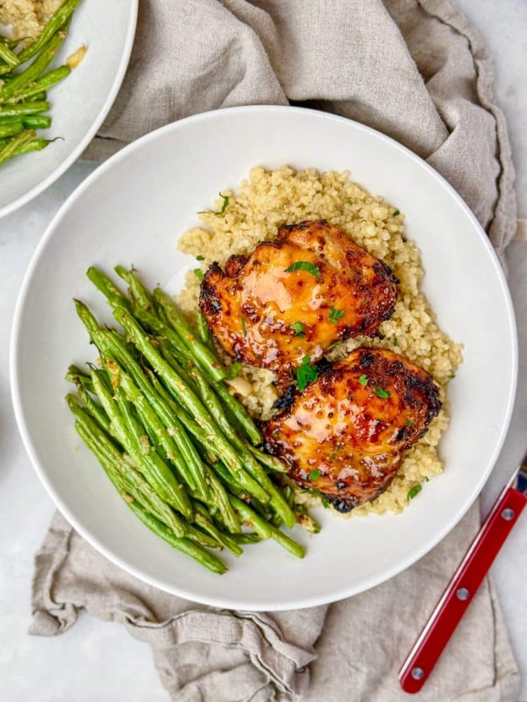 Air fryer honey mustard chicken thighs with caramelized glaze over quinoa and garlicky green beans with dipping sauce