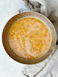 Mashed bananas whisked with peanut butter and egg whites in a mixing bowl