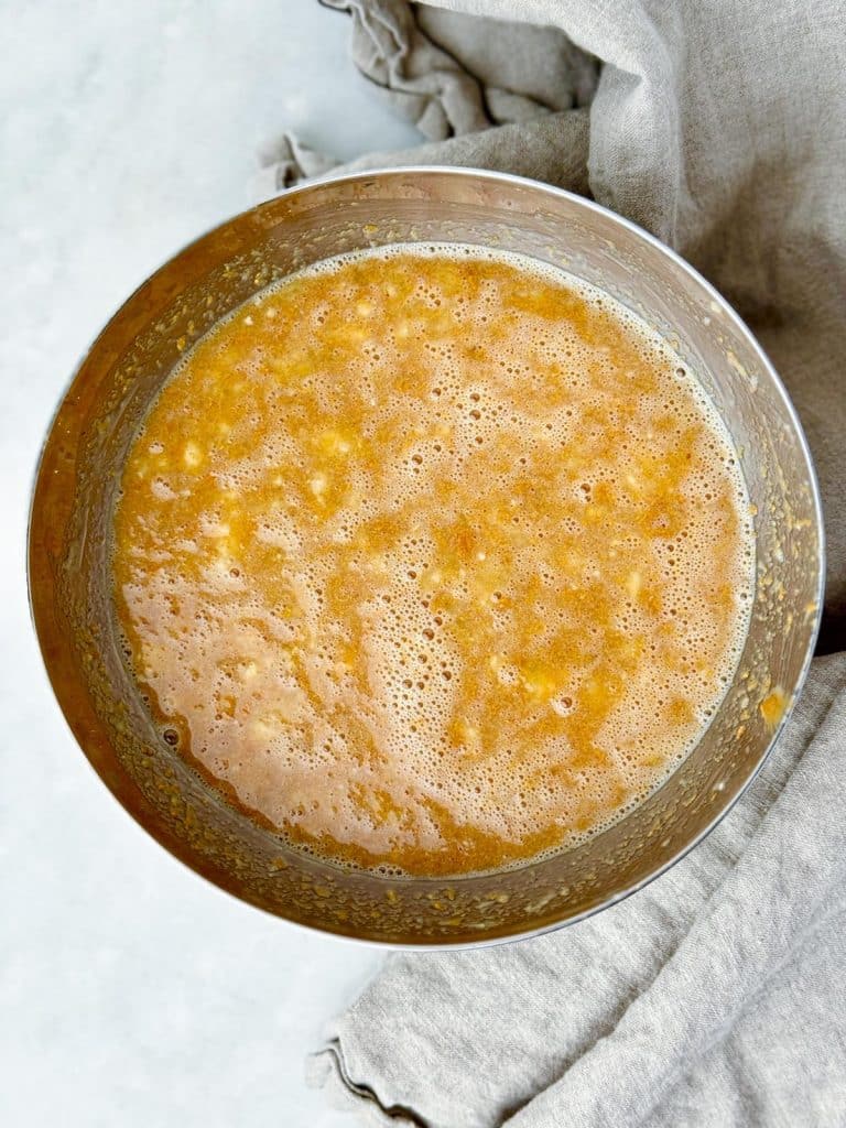 Mashed bananas whisked with peanut butter and egg whites in a mixing bowl