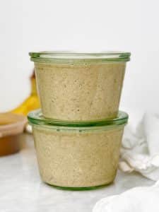 two glass weck jars filled with banana bread overnight oats mixture stacked and sealed with lids ready to refrigerate overnight