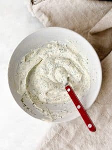 Homemade ranch dressing with herbs in a white bowl