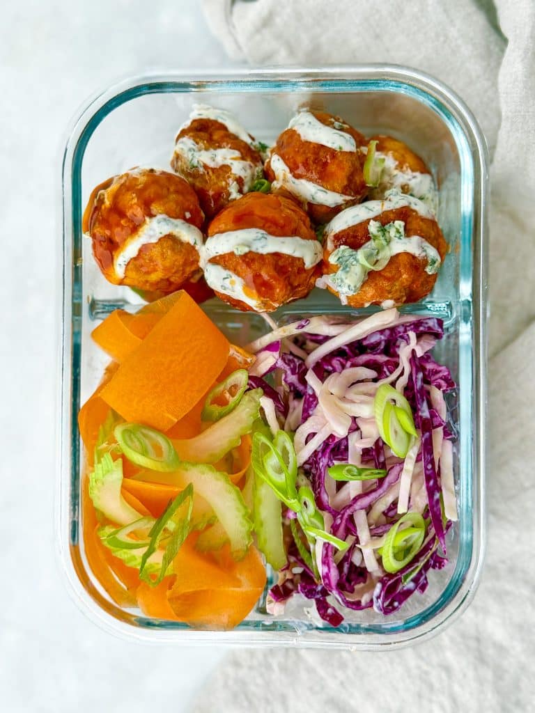 Buffalo chicken meatball meal prep container with slaw and vegetables