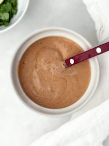 Smoky chipotle crema in a small white bowl with a red spoon