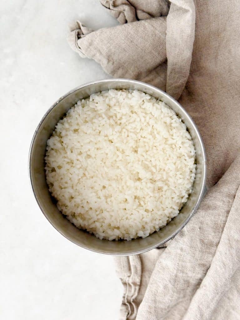 Freshly cooked sushi rice in a stainless steel bowl