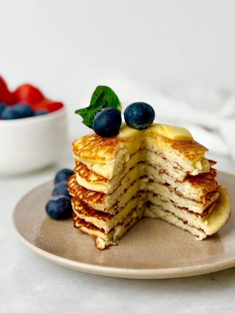 low carb cottage cheese pancakes cut open to show fluffy inside texture topped with butter and blueberries