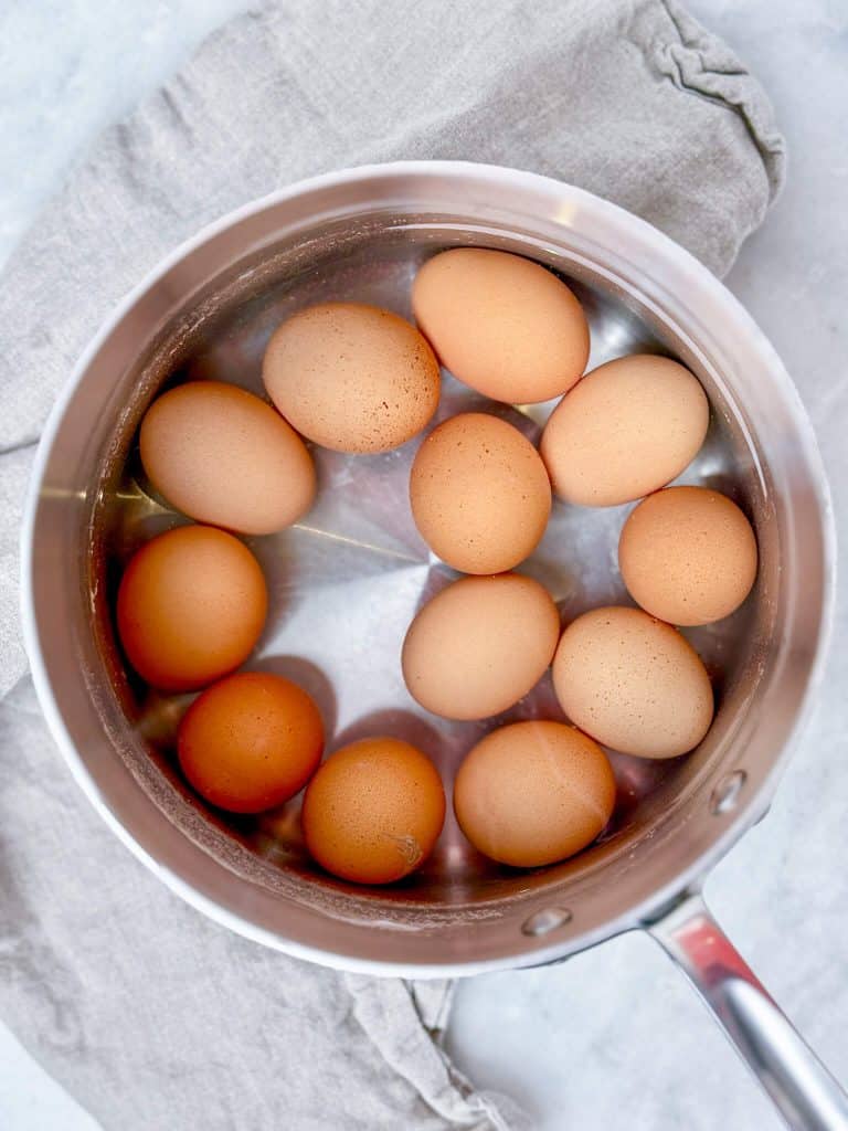 12 large brown eggs in a stainless steel pot of water to medium boil for avocado egg salad