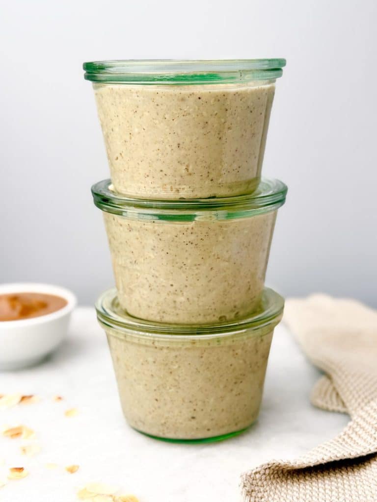 Three stacked glass jars of overnight oats ready for meal prep