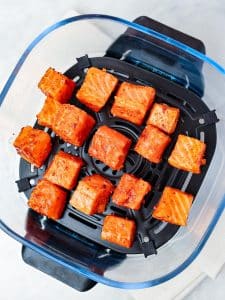 Crispy bang bang salmon cubes in the air fryer basket