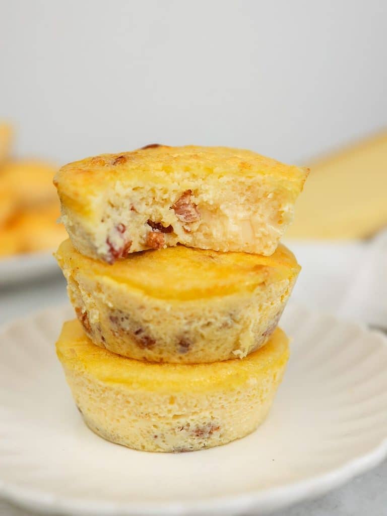 Stack of three quiche lorraine egg bites with a bite taken out of the top one