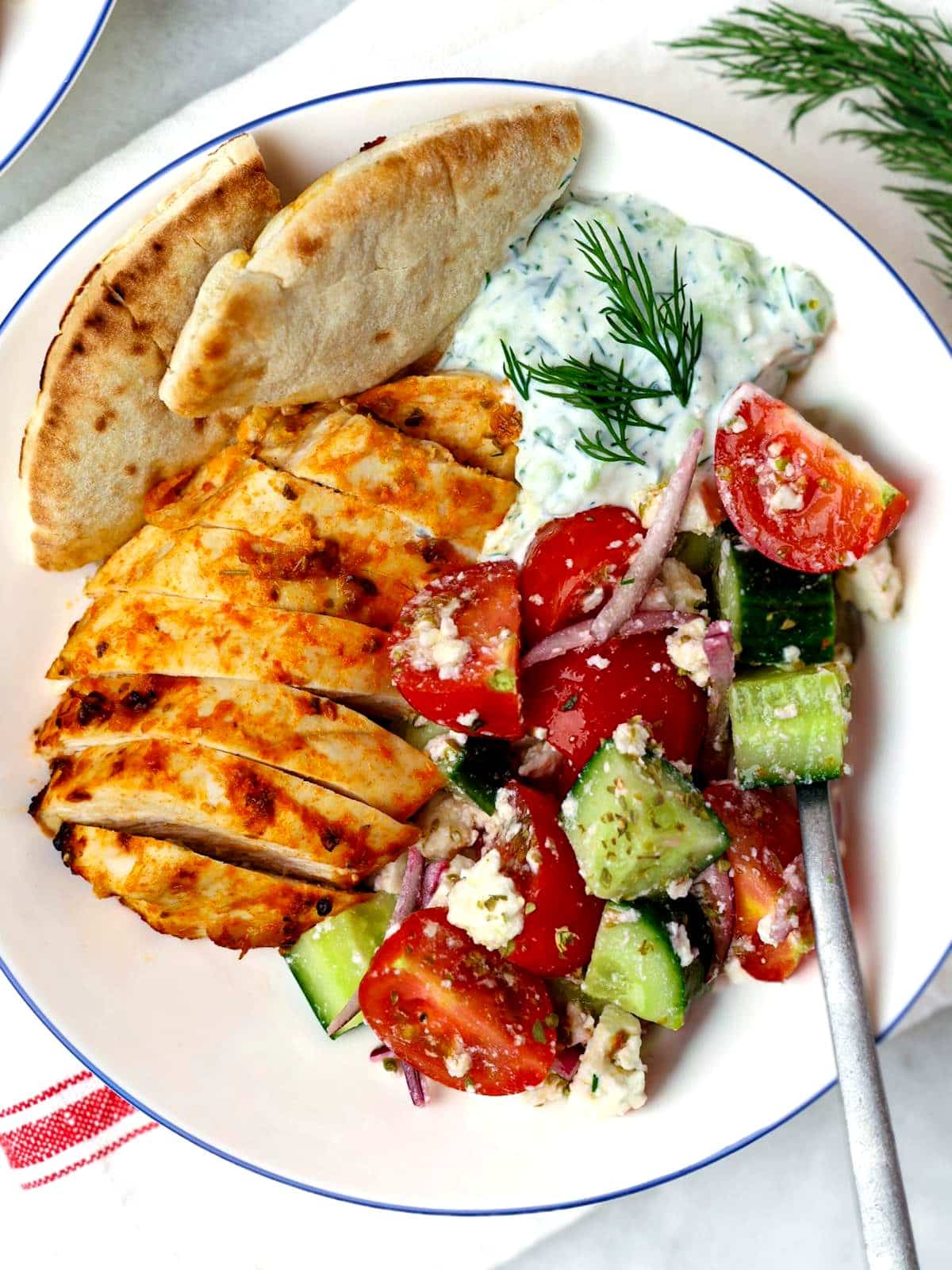 Greek chicken tzatziki bowls with marinated chicken, cucumber, tomatoes, feta, and tzatziki sauce