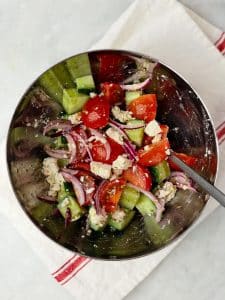 Greek salad with cucumber, cherry tomatoes, red onion, and crumbled feta