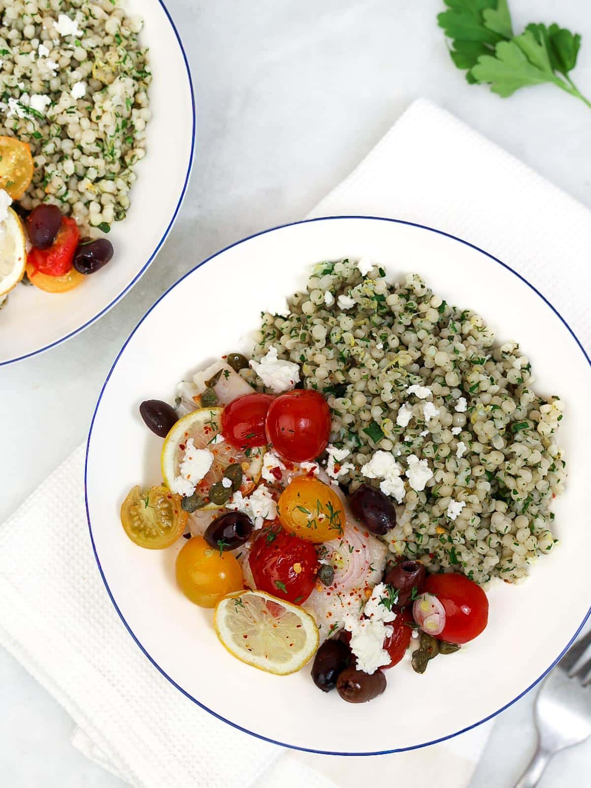 Air fryer Mediterranean cod in parchment paper with cherry tomatoes, olives, capers, and lemon
