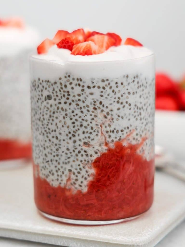 Strawberry rhubarb chia pudding close up showing the jam swirl through the glass