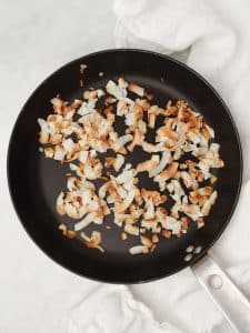Golden toasted coconut flakes in a dry skillet