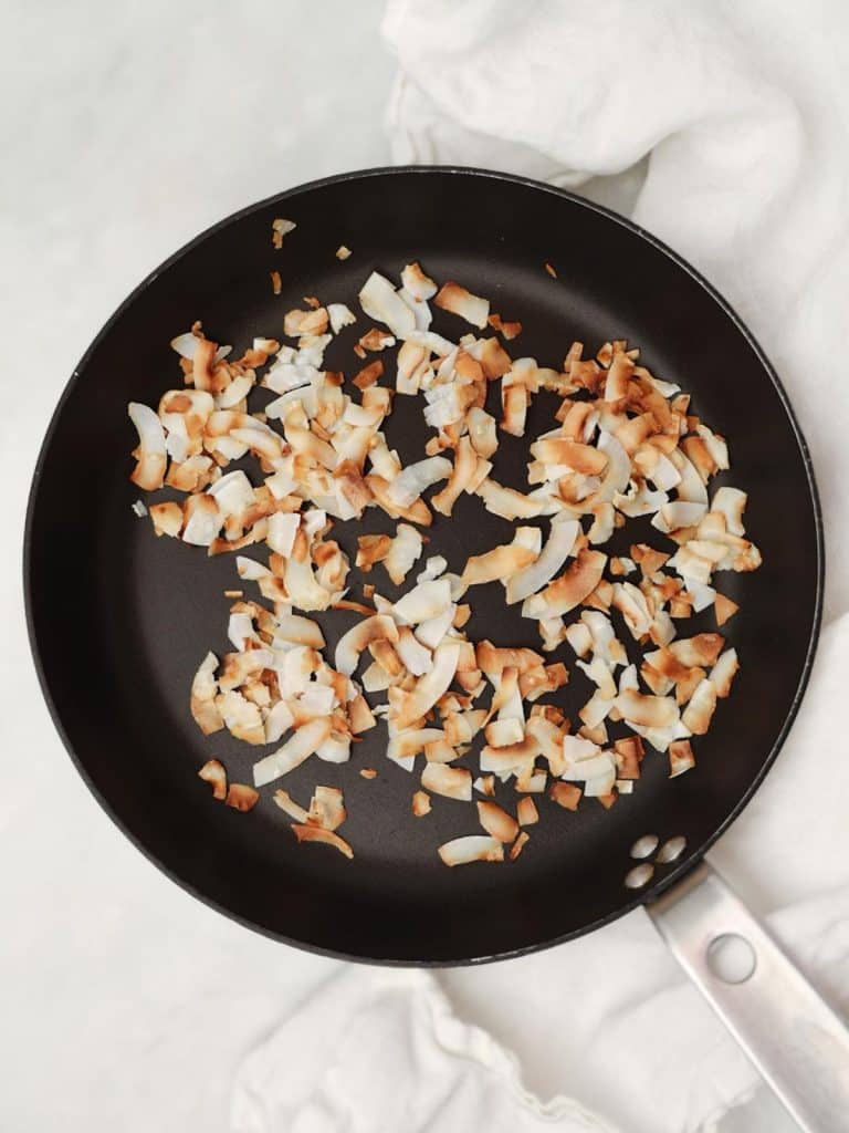 Golden toasted coconut flakes in a dry skillet