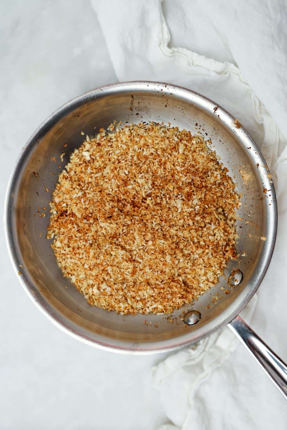 Toasted panko breadcrumbs golden brown in a skillet
