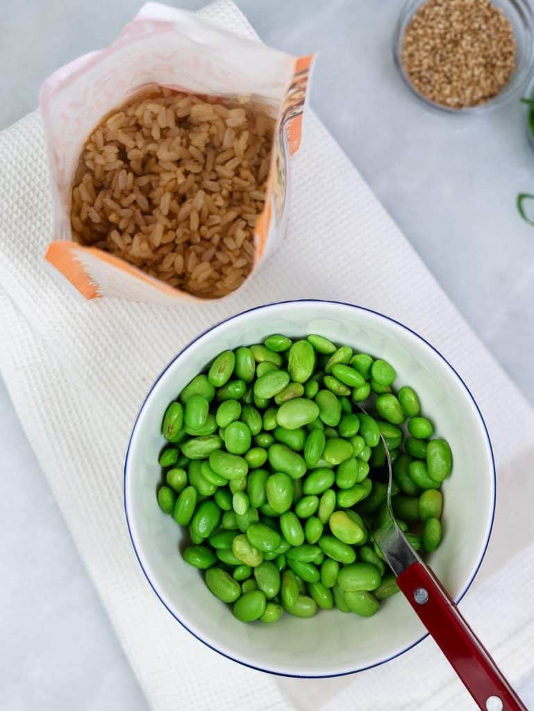Microwave brown rice pouch and a bowl of shelled edamame for the tofu bowl