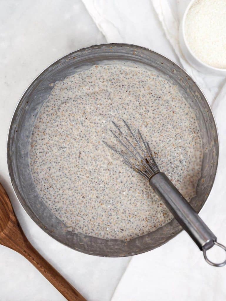 Thick set creamy coconut chia pudding in a metal bowl ready to layer into jars