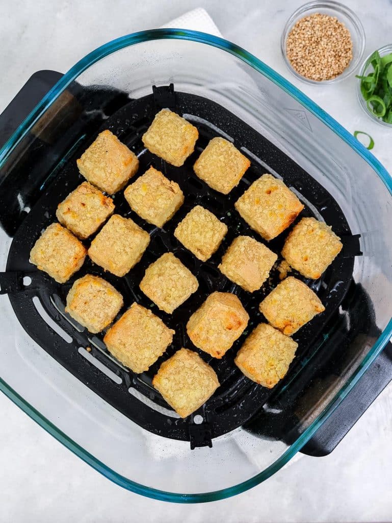 Golden crispy tofu cubes in the air fryer basket after cooking