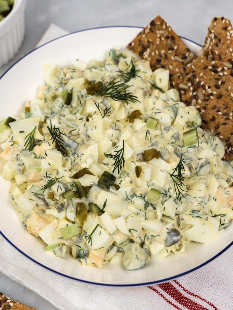 Healthy high-protein dill pickle egg salad with seed crackers and fresh dill