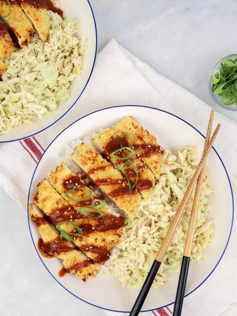 Easy air fryer chicken katsu sliced over rice with sesame cabbage slaw and chopsticks