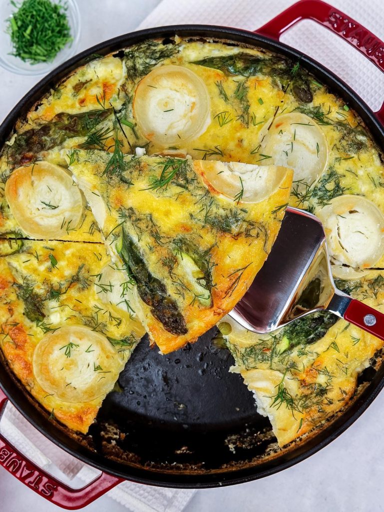Easy spring vegetable frittata with one slice lifted out of the pan