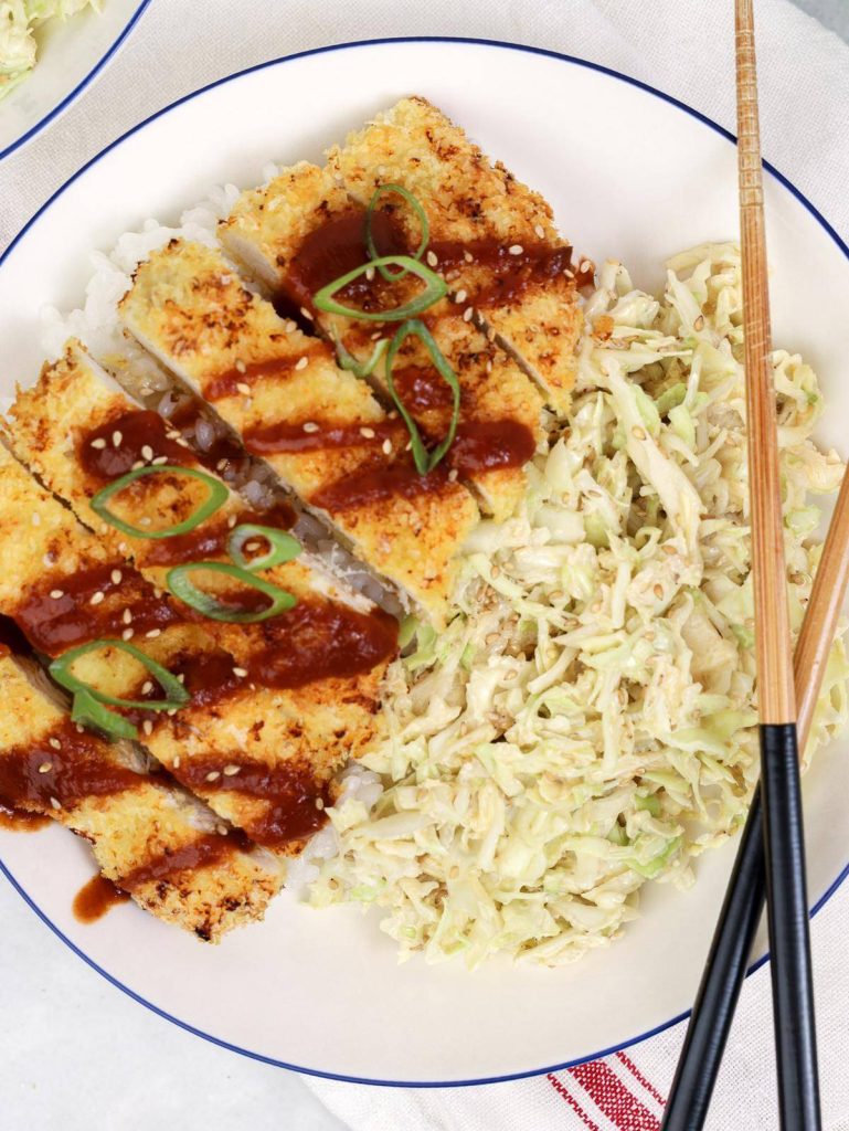Healthy air fryer chicken katsu close-up with tonkatsu sauce drizzle, sesame seeds, and green onion