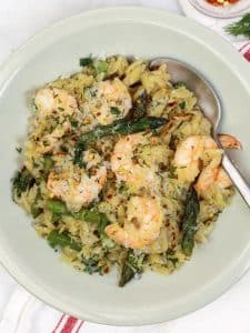 High protein shrimp and asparagus orzo served in a green bowl