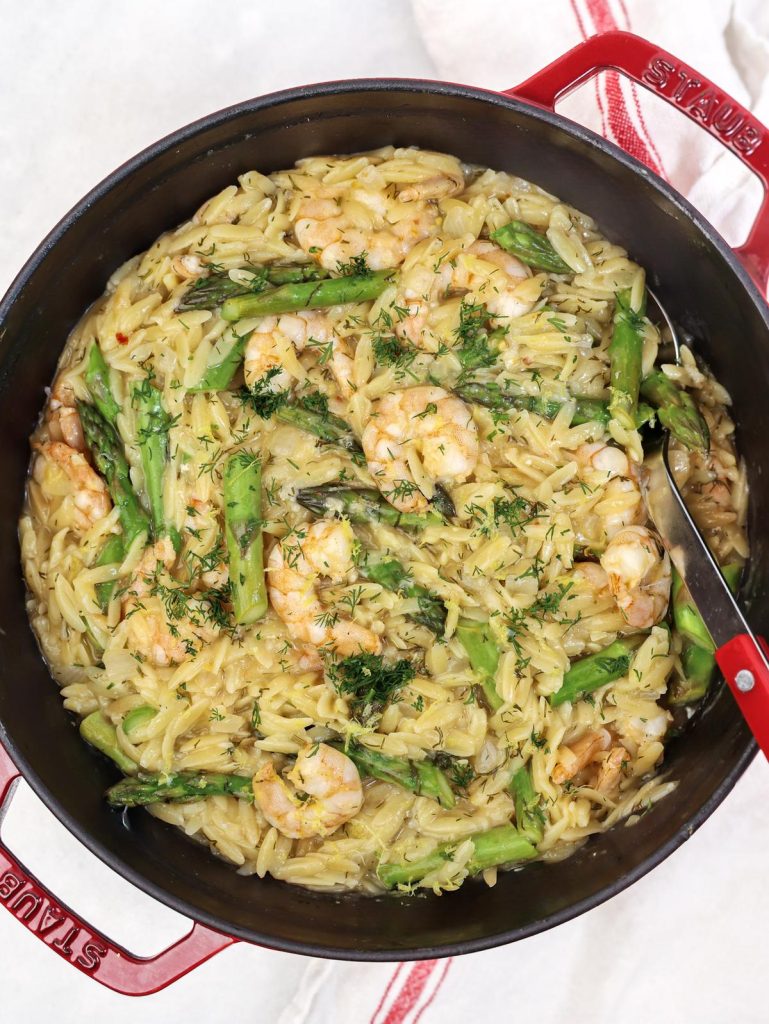 One pan shrimp and asparagus orzo with fresh dill in the pot