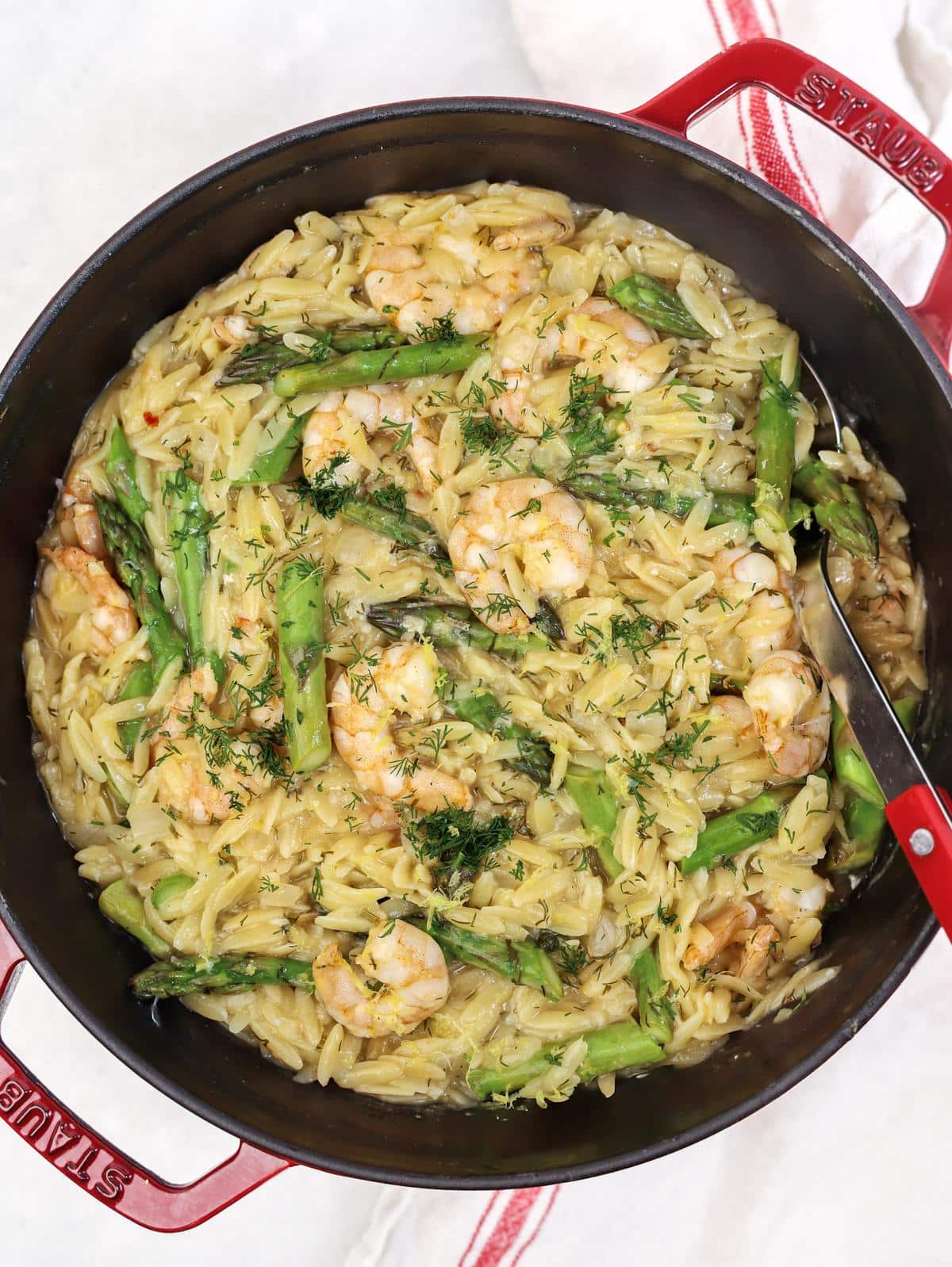 One pan shrimp and asparagus orzo with fresh dill in the pot