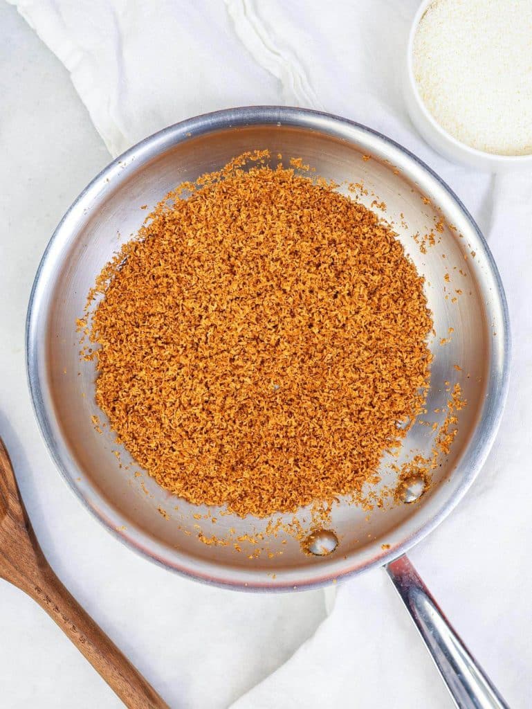 Finely shredded coconut toasted to a deep golden brown in a stainless steel pan
