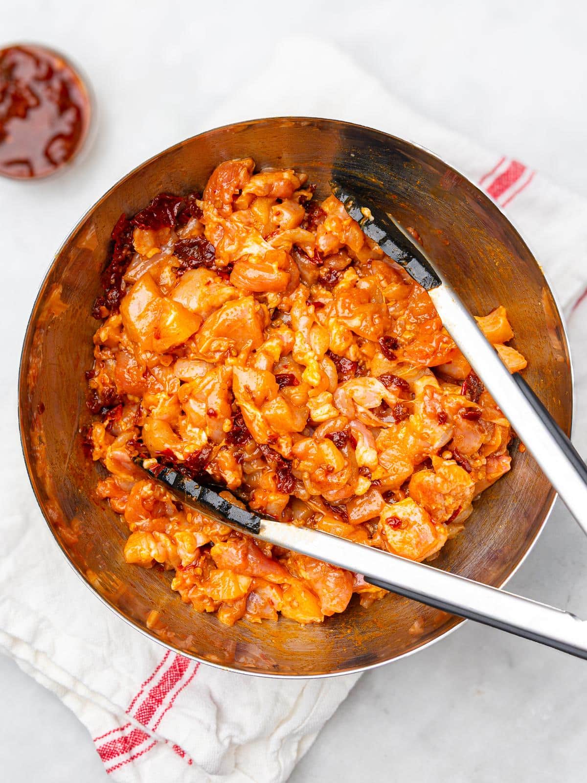 Diced chicken thighs tossed in chipotle adobo marinade in a bronze bowl