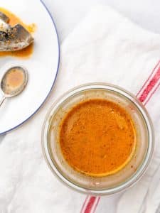 Chipotle honey vinaigrette in a glass jar beside a spoon