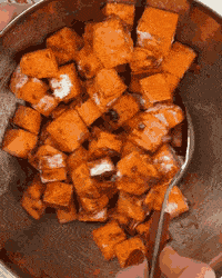 Tossing diced sweet potato with seasoning for a savory cottage cheese breakfast bowl
